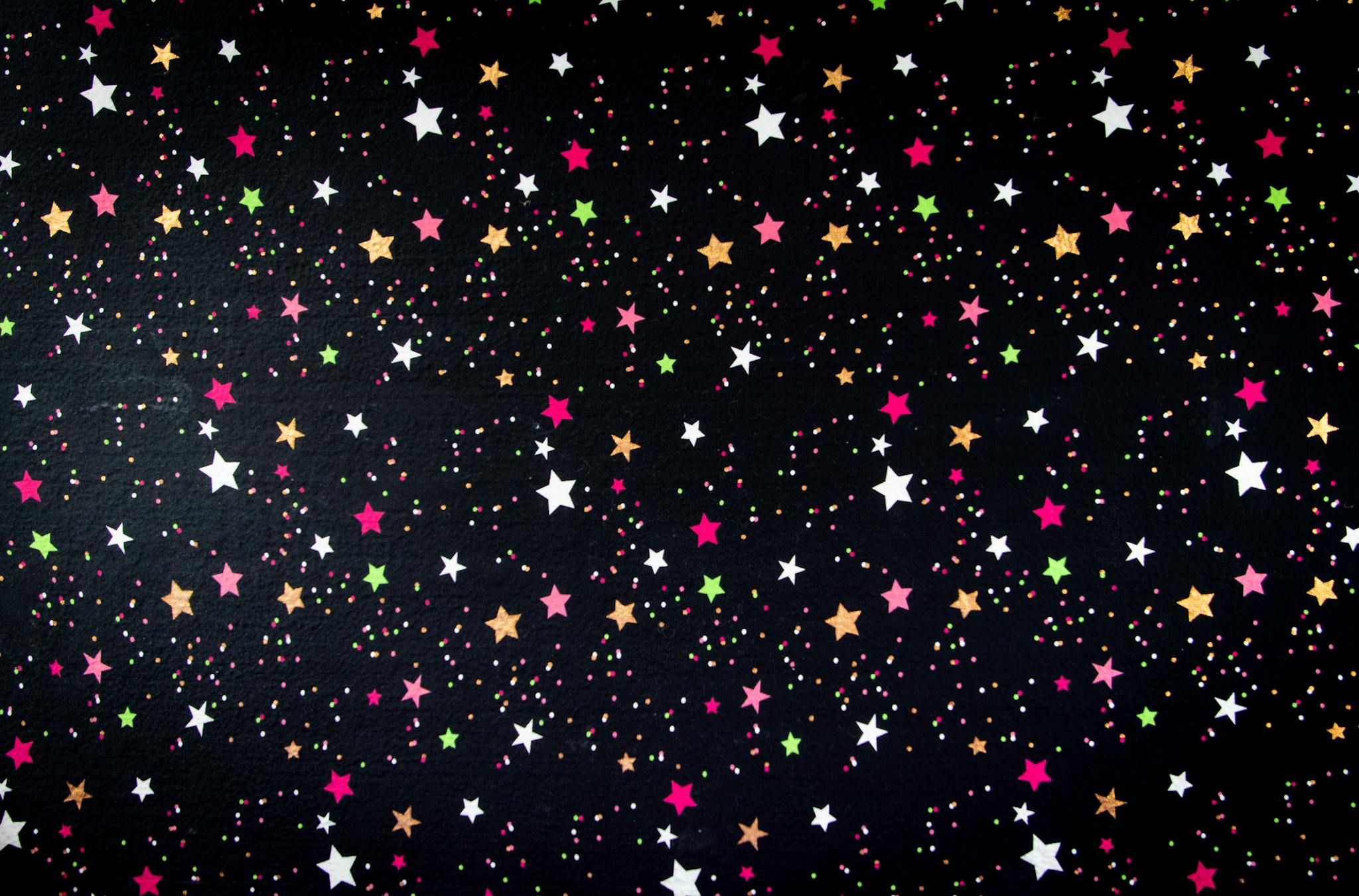 Vibrant star pattern with colorful dots against a black background, perfect for festive designs.